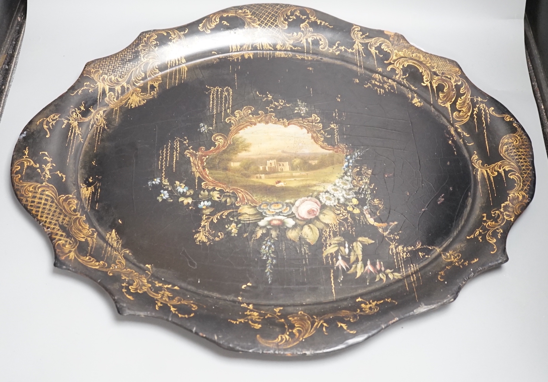 A Victorian papier mache tray, painted with ruins in a landscape - 64cm wide